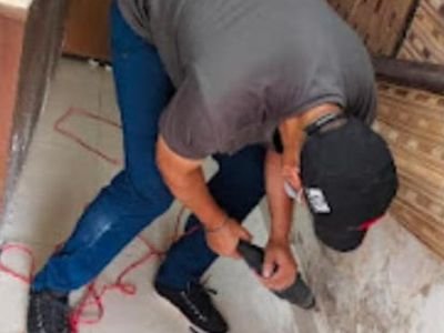 Technician performing drill-fill-seal anti-termite treatment