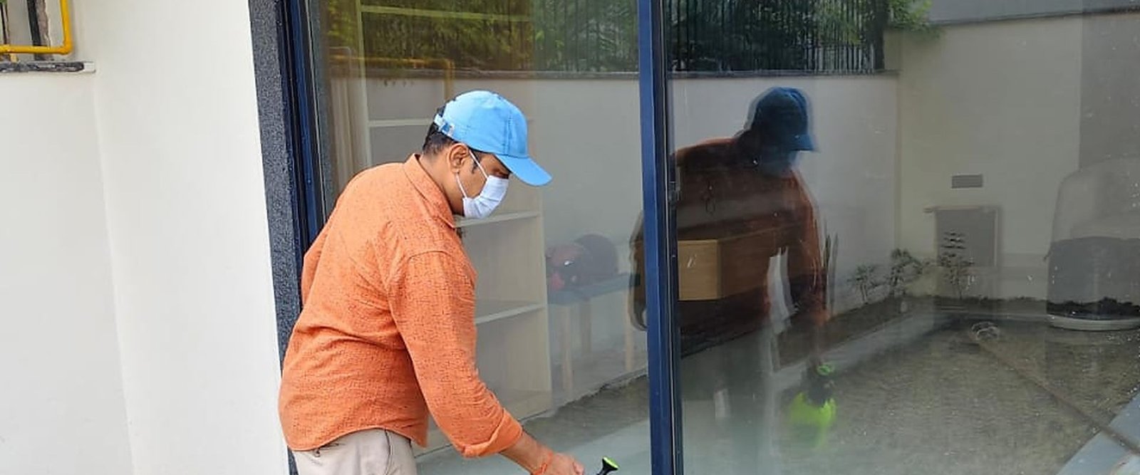 Jai Bharat Pest Control technician spraying anti-termite treatment at a home entrance in Indirapuram
